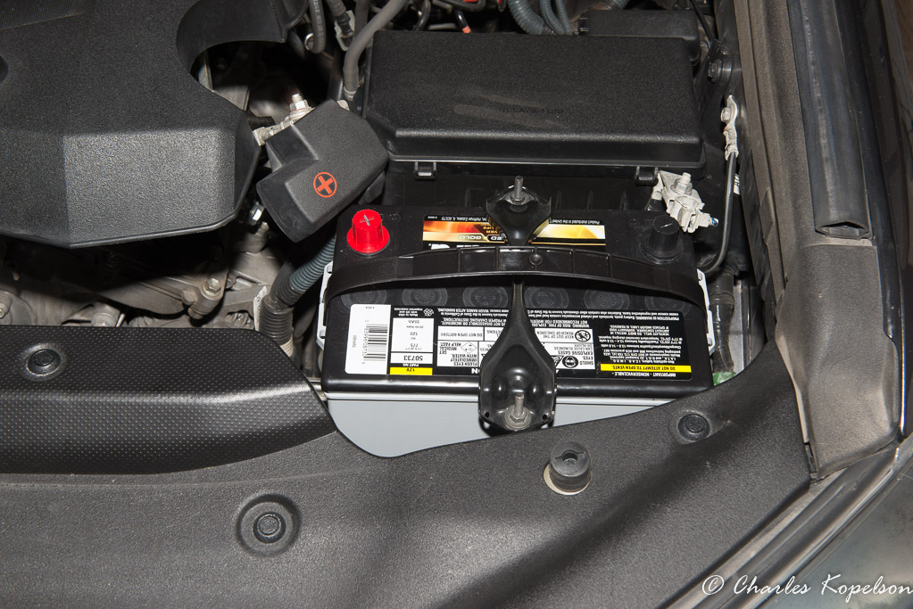 Drop the new battery in, position the clamp rods and snug down. Don't make it so tight that it crushes the battery.