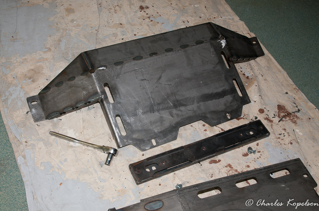 Clean all the parts with solvent before painting. This shows the t-case skid plate and the T-case cross member spacer.